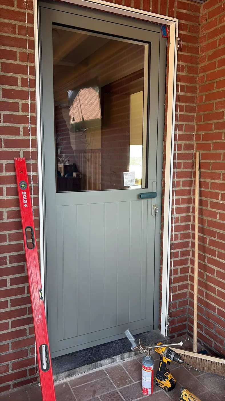 Groene achterdeur met glas tijdens de plaatsing