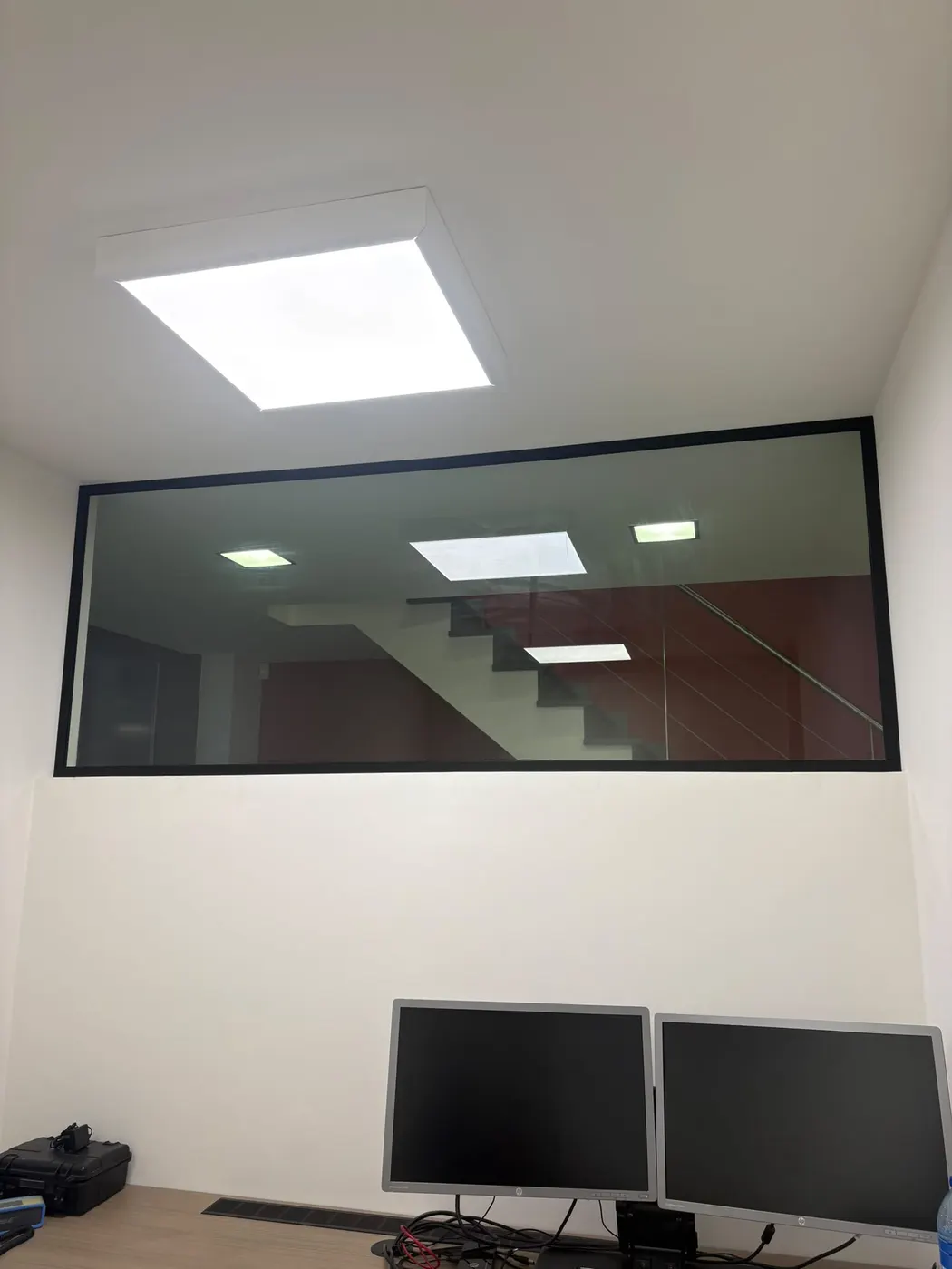 Glazen binnenwand met zwart kader in een kantoorruimte