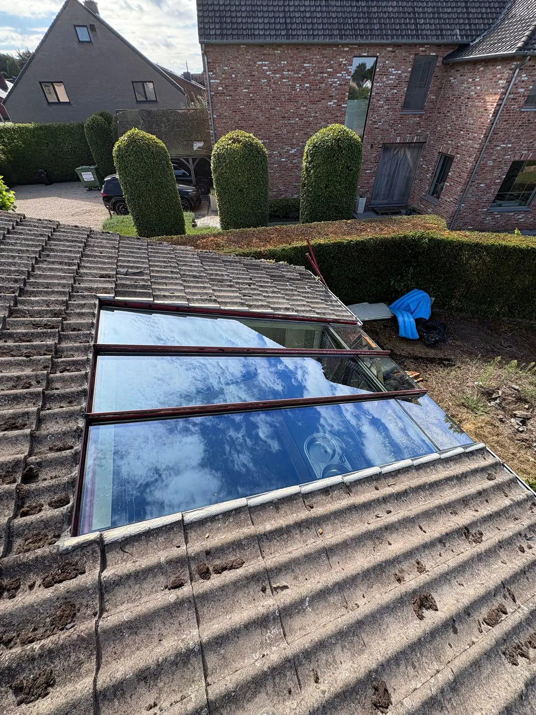 Nieuw dakraam met glas in een pannendak