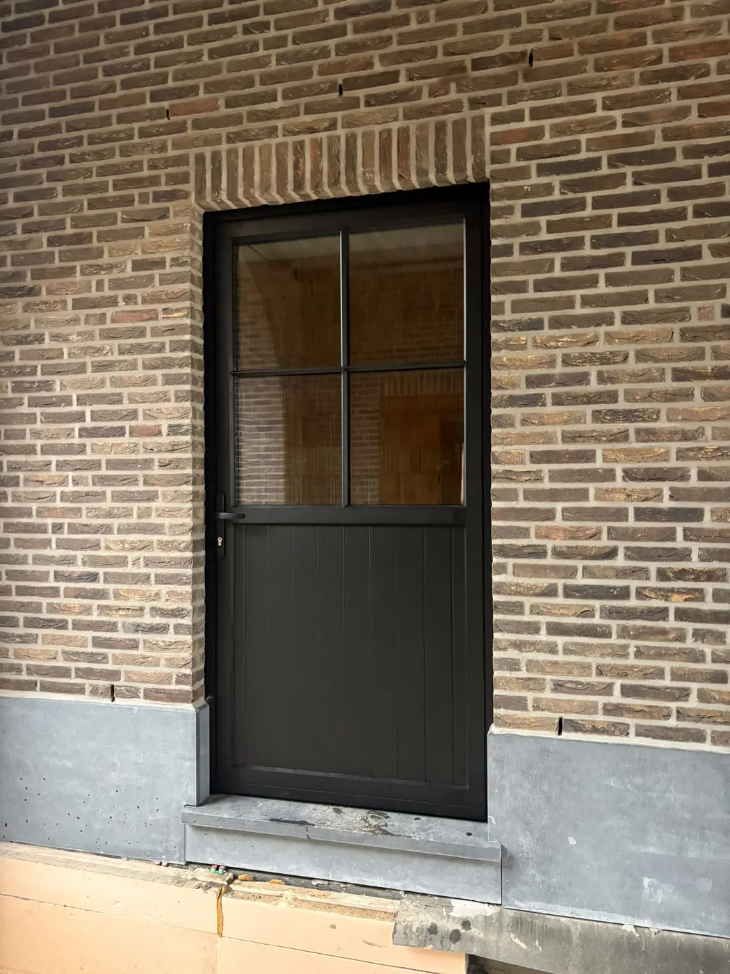 Donkere achterdeur met glasverdeling na renovatie