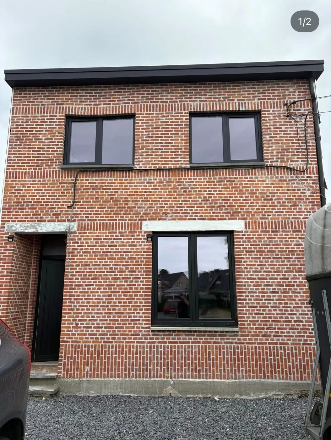 Bakstenen woning met nieuwe donkere ramen en deur
